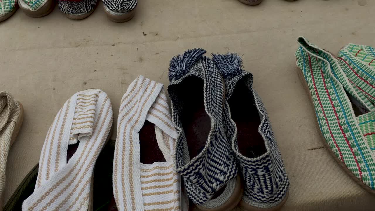 Prise de vue au stabilisateur, à droite, d'espadrilles artisanales au marché aux puces