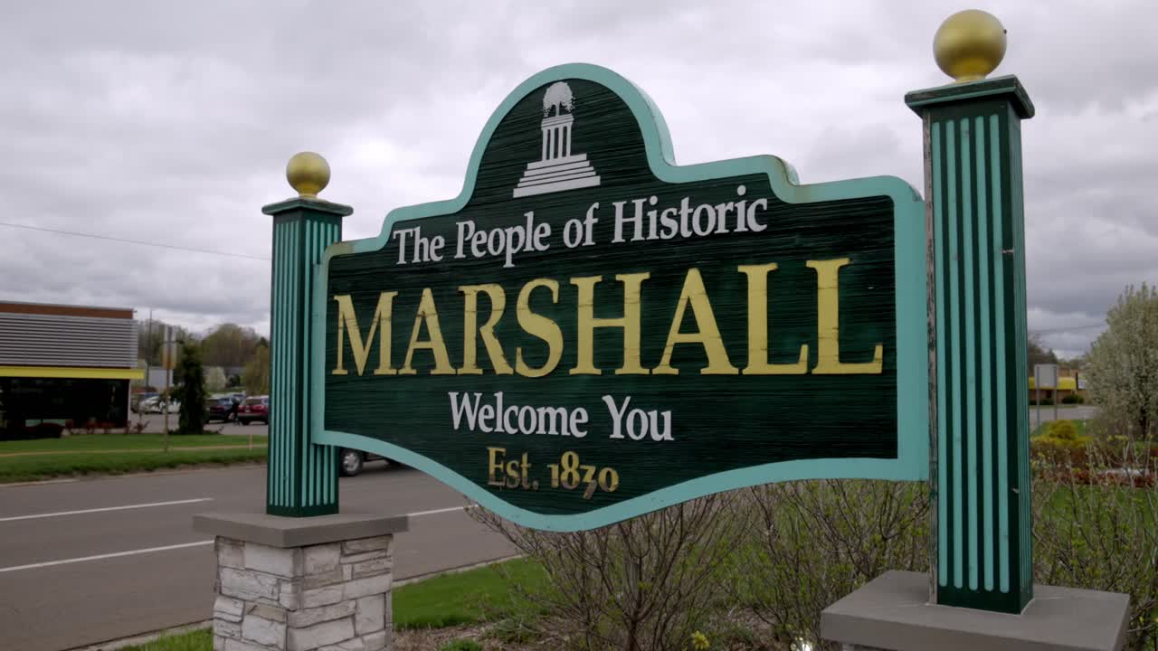 The People of Historic Marshall, Michigan Welcome You sign with gimbal video walking forward close up