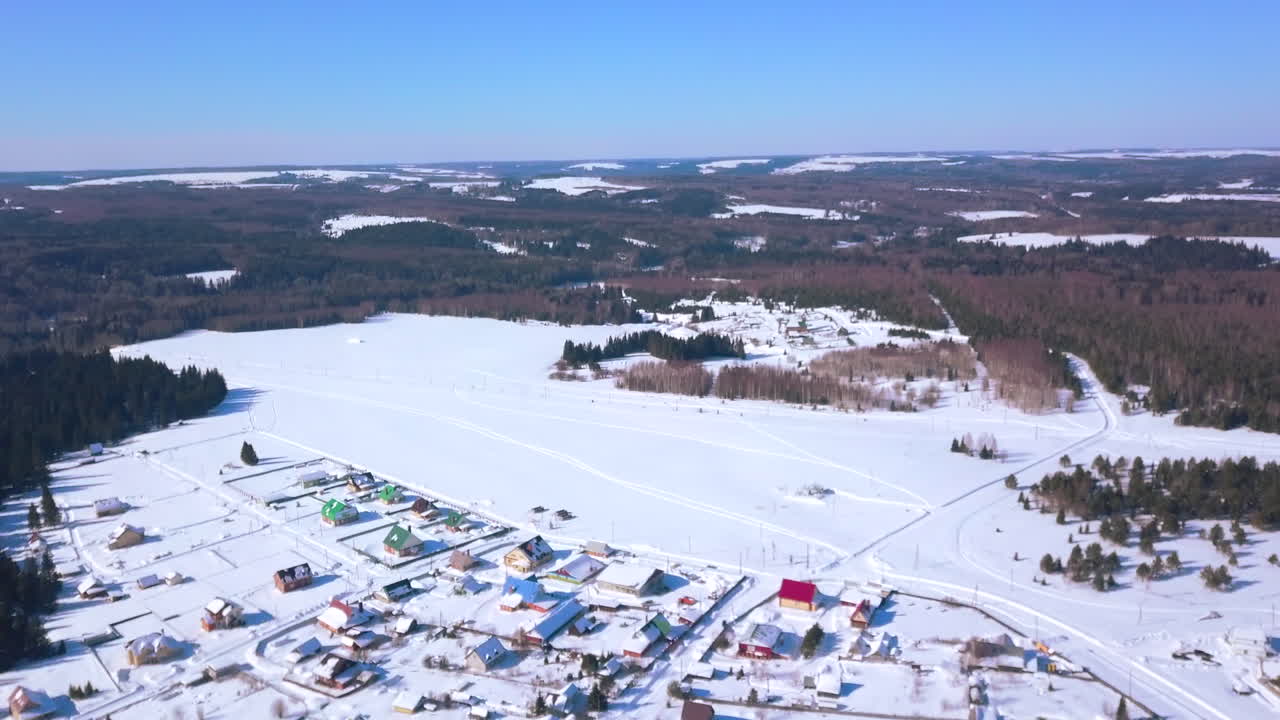 Zasněžený pohled na vesnici z ptačí perspektivy