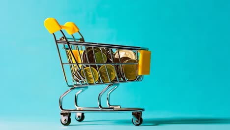 un carrito de compras lleno de monedas en un fondo azul