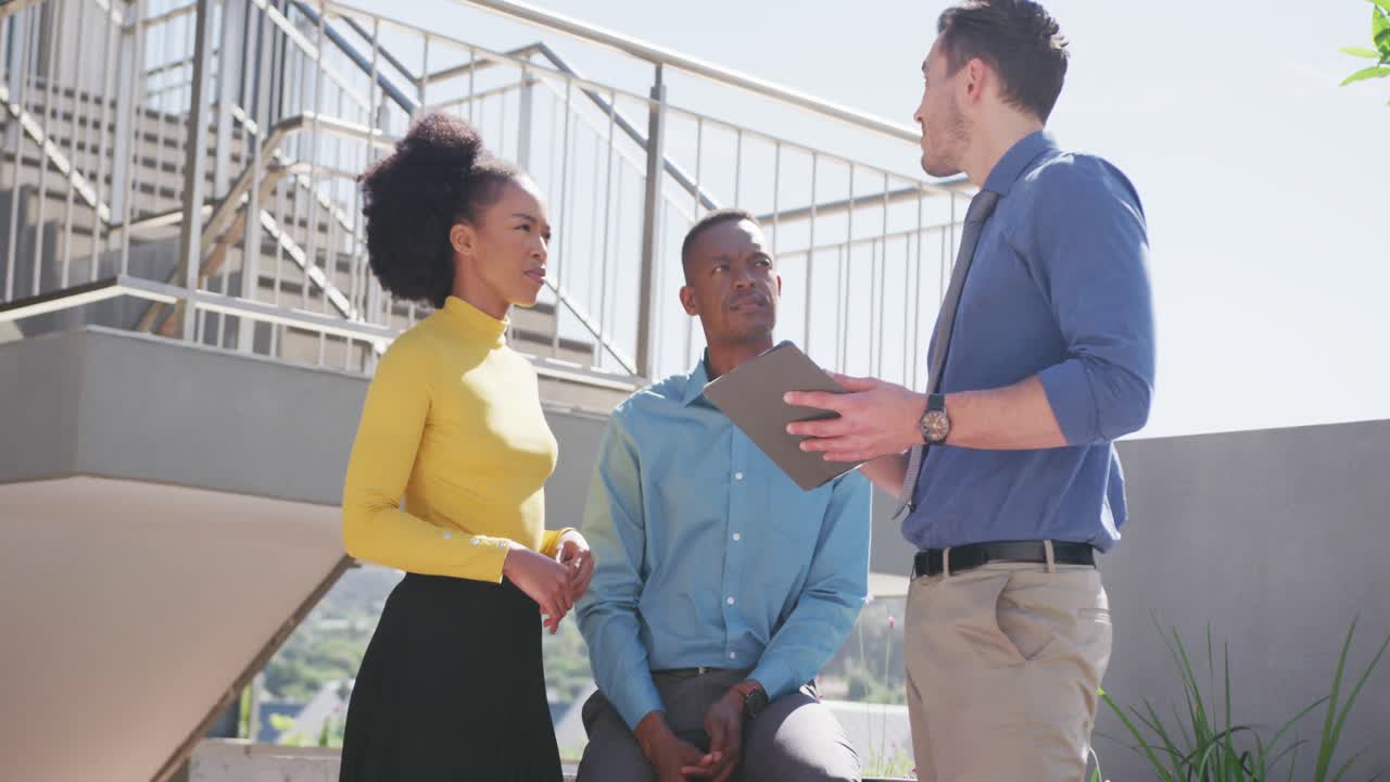 personas de negocios felices y diversas discutiendo el trabajo y usando la tableta en la oficina, cámara lenta