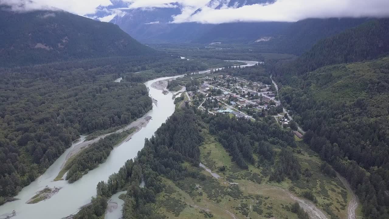 nublado vuelo aéreo por el valle del río hasta la ciudad de bella coola