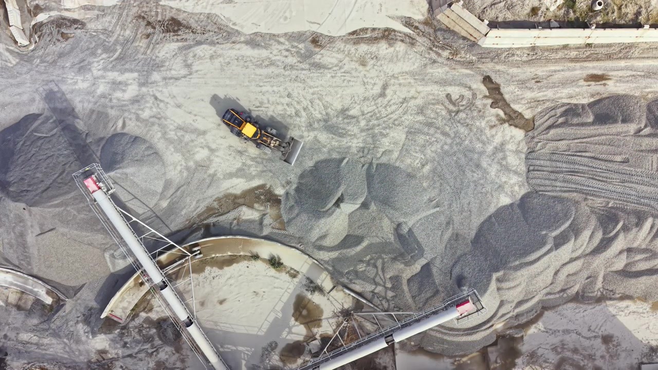 Granite quarry seen from above with equipment moving stone and gravel on site in an active work environment