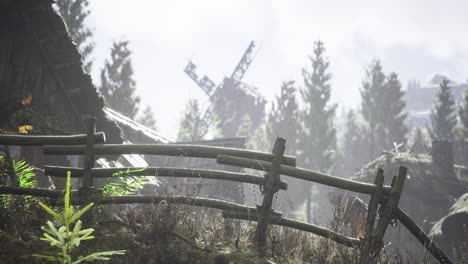 landscape of a misty rural area with a windmill and wooden fence
