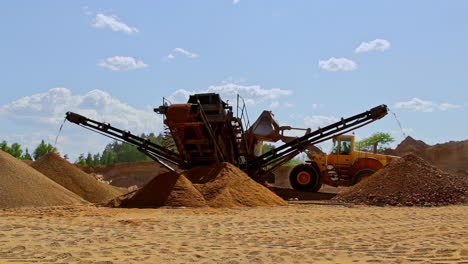 slow motion of a stone crushing machine producing sand at mining site