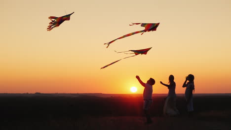 Children-With-Mom-Play-A-Kite-At-Sunset-On-A-Summer-Evening-Active-Parents-And-Children