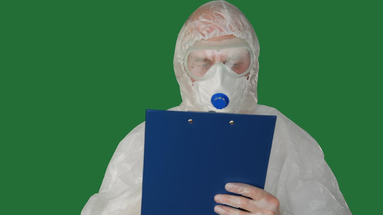 보호 의복과 마스크를 입은 의료 종사자가 클립보드에 글을 쓰고, 안전 의복을 입은 남자들이 녹색 배경에 클립보드를 입고, 보호 의상을 입은 의사가 환자를 검사합니다.
