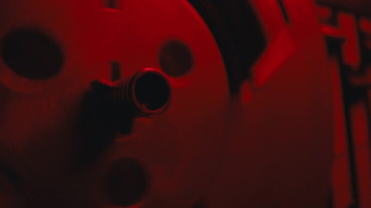 Un gros plan sur un magnétophone vintage dans une lumière rouge clignotante.