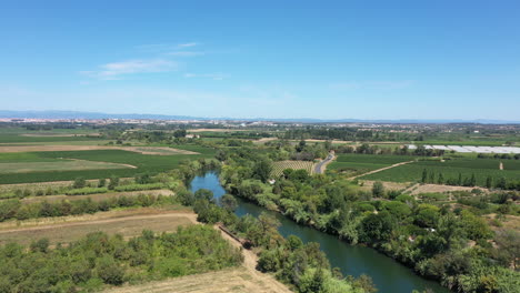 Orb-River-Entlang-Einer-Straße-Und-Weinberge-Frankreich-Luftaufnahme-Sonniger-Tag