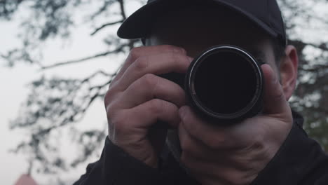 caucasian photographer using camera and taking photos, face extreme closeup, front view