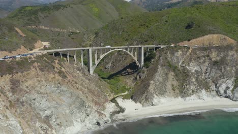 drone flies above iconic bixby creek bridge in big sur, california on highway 1 - summer day