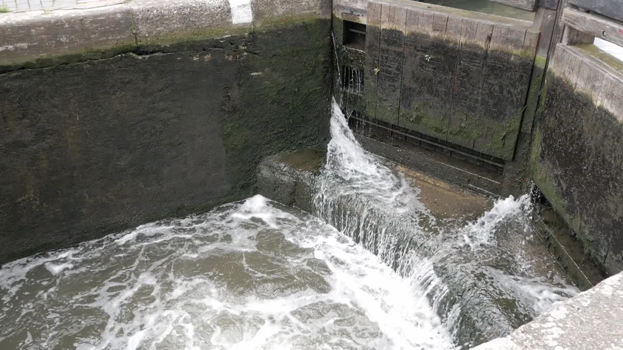 Canal lock gates letting water in to have chamber filled