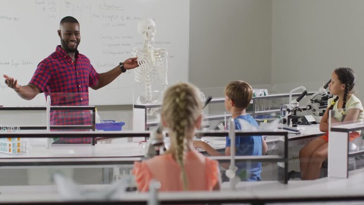 Video of happy african american teacher with class of diverse pupils during anatomy lesson