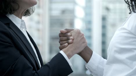 sorridente donna caucasica che stringe la mano al collega