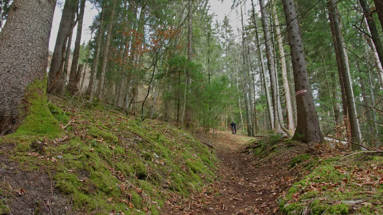 Horský cyklista sjíždí rokli ve vysoké rychlosti.