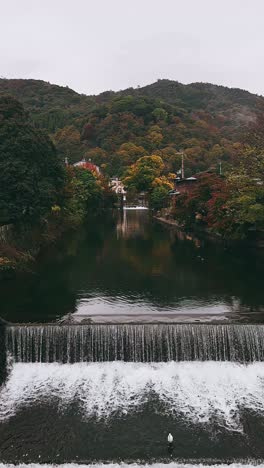 autumn scenery in a japanese village with a river and waterfall