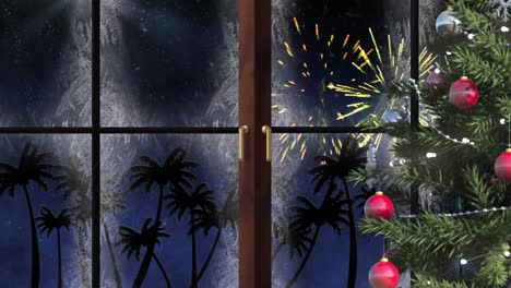 Christmas-tree-and-wooden-window-frame-against-palm-trees-and-fireworks-exploding-on-blue-background
