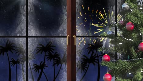 christmas tree and wooden window frame against palm trees and fireworks exploding on blue background