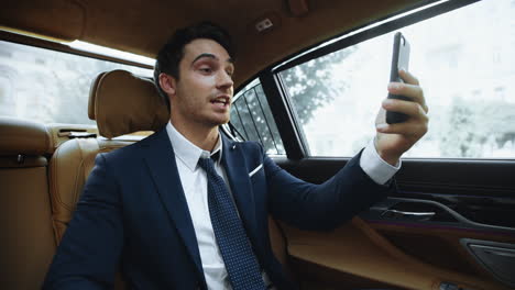 cheerful business man having video call in car