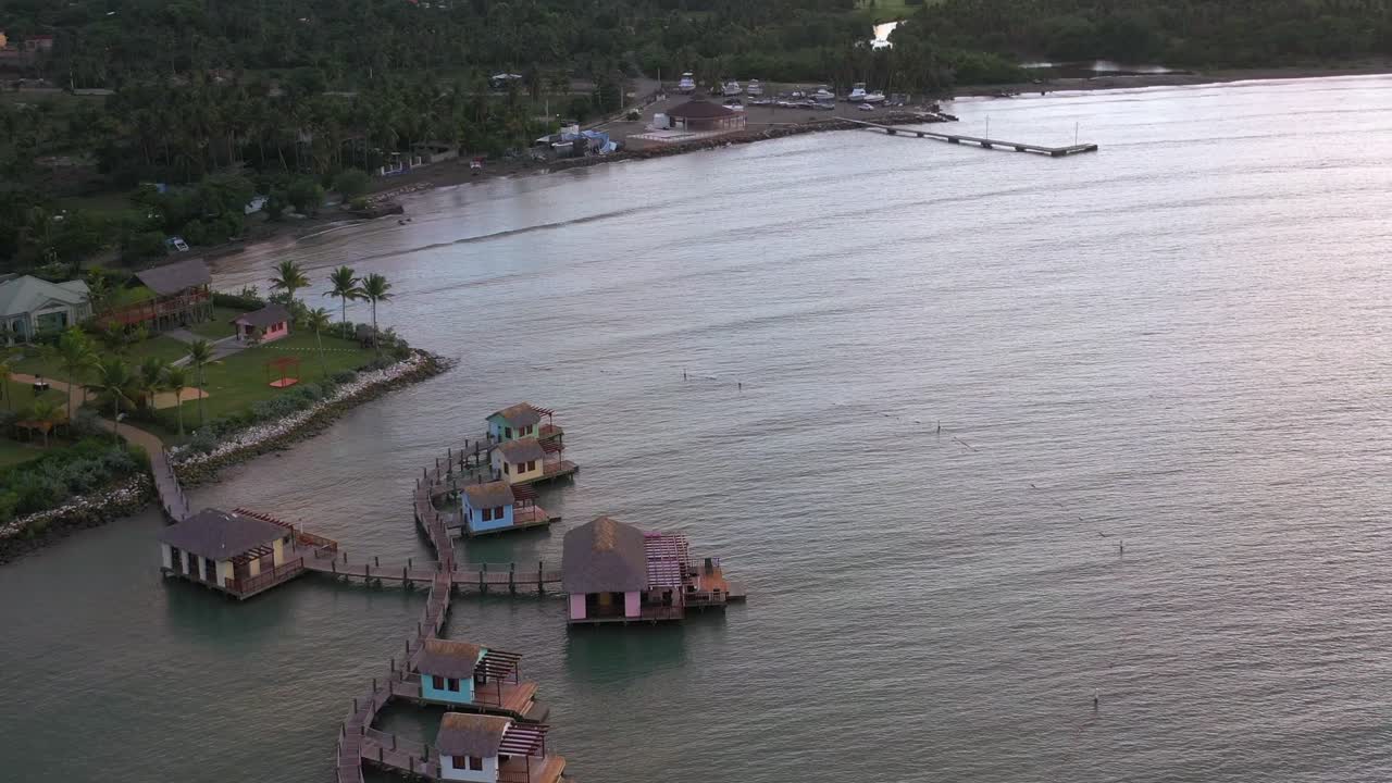 Reveal drone shot of water villas bungalows resort in Amber Cove