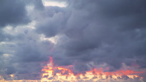 Dicke,-Flauschige-Schicht-Dichter-Grauer-Wolken-Sammelt-Orangeroten-Glanz-Vom-Niedrigen-Sonnenuntergang,-Während-Sie-Am-Himmel-Schweben