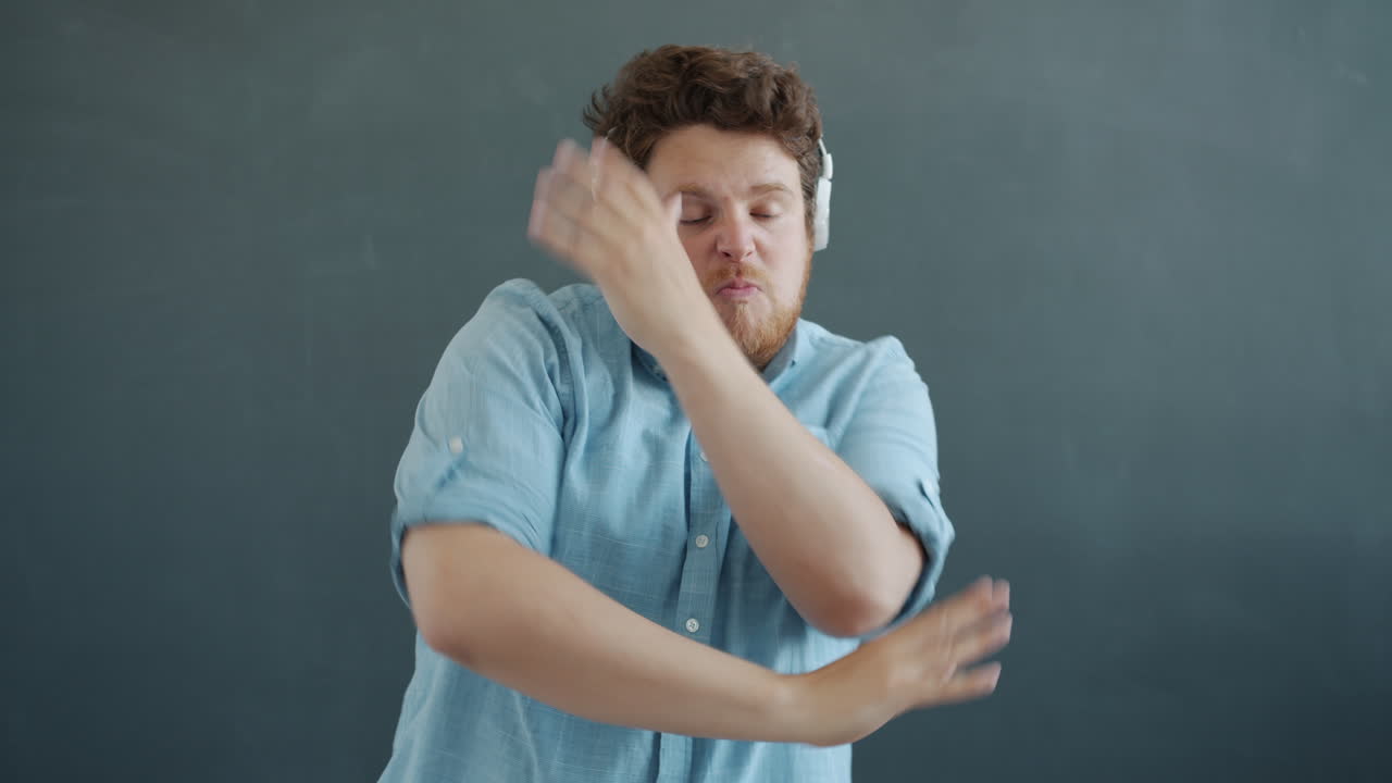 мужчина танцует с наушниками.