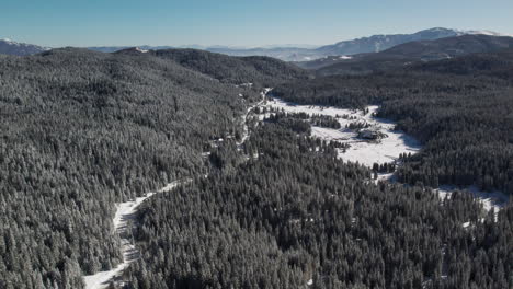 Twisted-road-covered-with-snow-passing-trough-a-forest