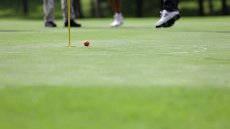 golfer misses putt on the green, low shot and reaction