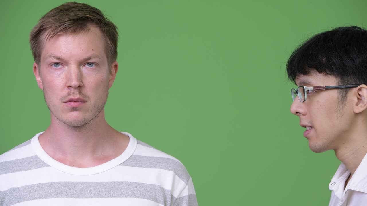 분노한 젊은 아시아 사업가가 젊은 스칸디나비아 사업가에게 비명을 지르고 있다.