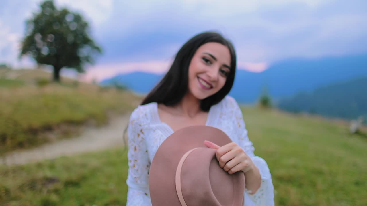 Lovely young caucasian bride. Joyful bride in wonderful wedding dress in field against mountains