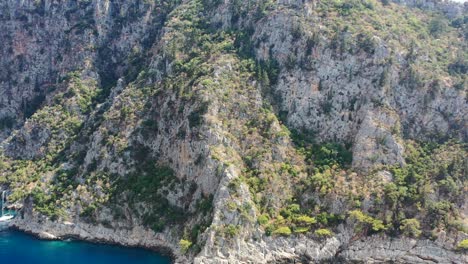 Luftdrohne-Umkreist-An-Einem-Sonnigen-Sommertag-Große-Grüne-Bergklippen-Um-Das-Schmetterlingstal-In-Fethiye,-Türkei