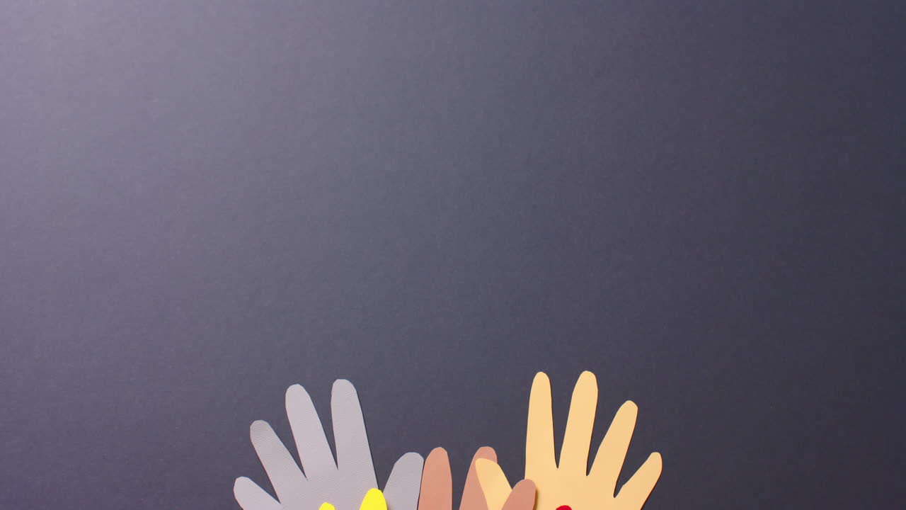 복사 공간과 함께 회색 배경에 다채로운 종이로 만든 손을 가까이 붙입니다.