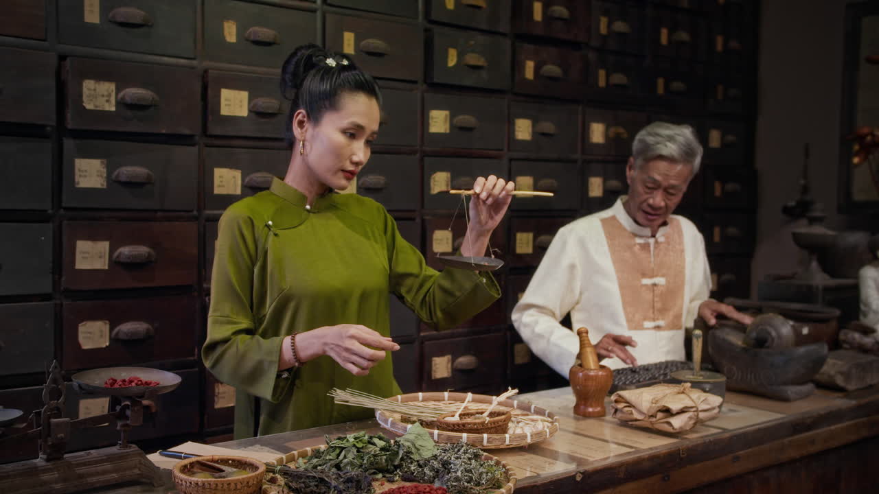 Mature Herbalist Teaching Young Daughter at Pharmacy