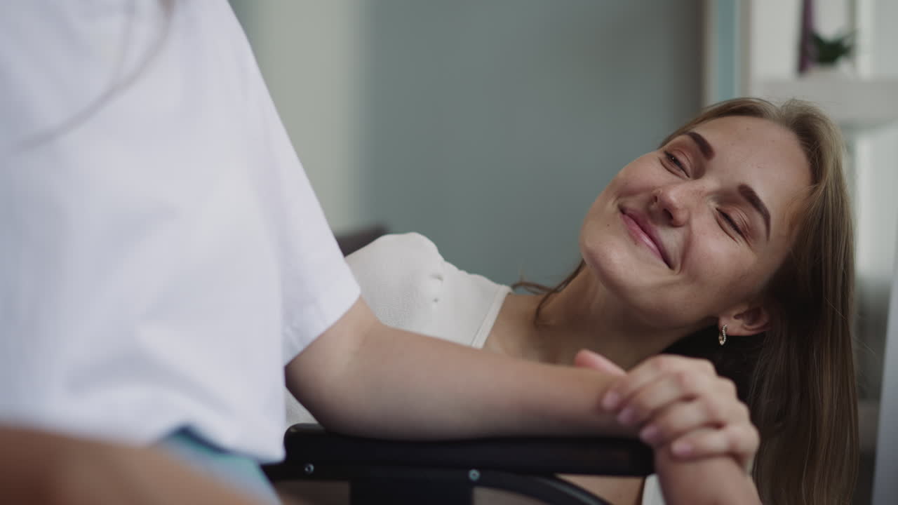 Loving blonde woman gently strokes hand of disabled partner