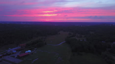 Vista-Aérea-De-Drones-Hacia-Atrás,-Sobre-El-Campo,-Cielo-Púrpura,-En-Una-Colorida-Puesta-De-Sol-O-Anochecer,-En-Albysjon,-Tyreso,-Suecia