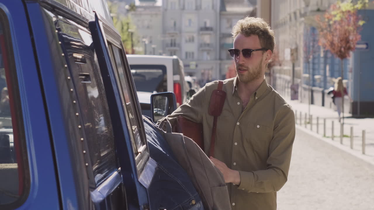 어린 소년은 자동차 여행 전에 밴 옆에 두 명의 소녀를 허용하기 위해 캐러밴의 문을 엽니다