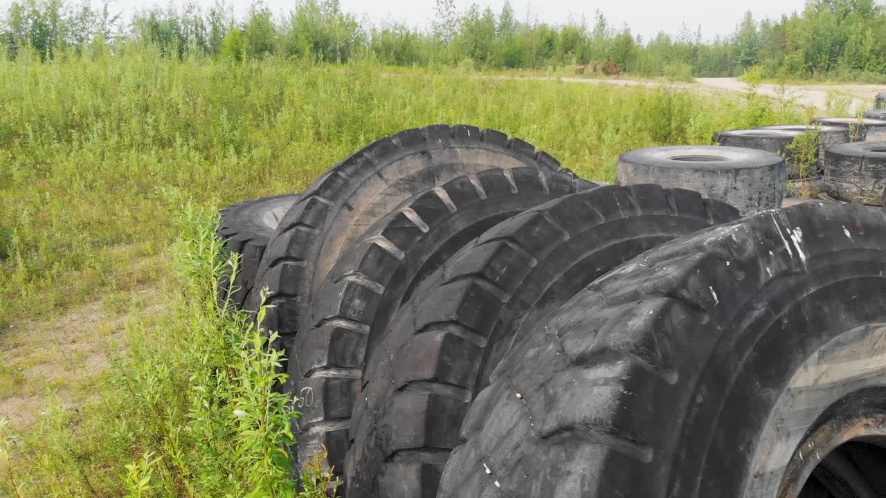 video de drones de 4k de una pila de neumáticos de excavadoras gigantes descartadas en el desierto cerca de fairbanks, ak durante el día de verano-4