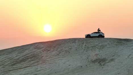 Mann-Sitzt-Auf-Einem-Einsamen-Hügel-Mit-Blick-Auf-Einen-Sonnenaufgang-Auf-Einem-Mazda-auto