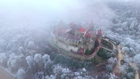 burg kreuzenstein on misty winter in leobendorf, austria - aerial drone shot