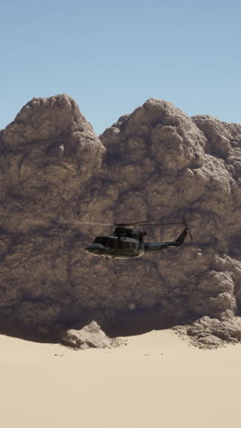 military helicopter flying over desert landscape