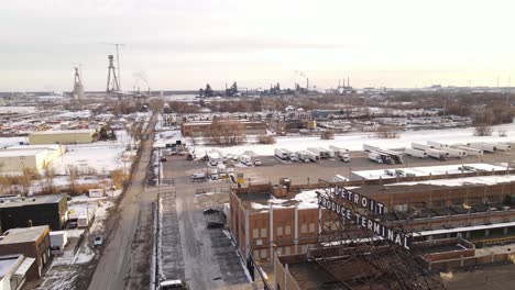 Toma-Aérea-Ascendente-De-La-Industria-De-Detroit-Durante-Un-Frío-Día-De-Invierno-Con-Un-Paisaje-Cubierto-De-Nieve,-Estableciendo-Una-Toma