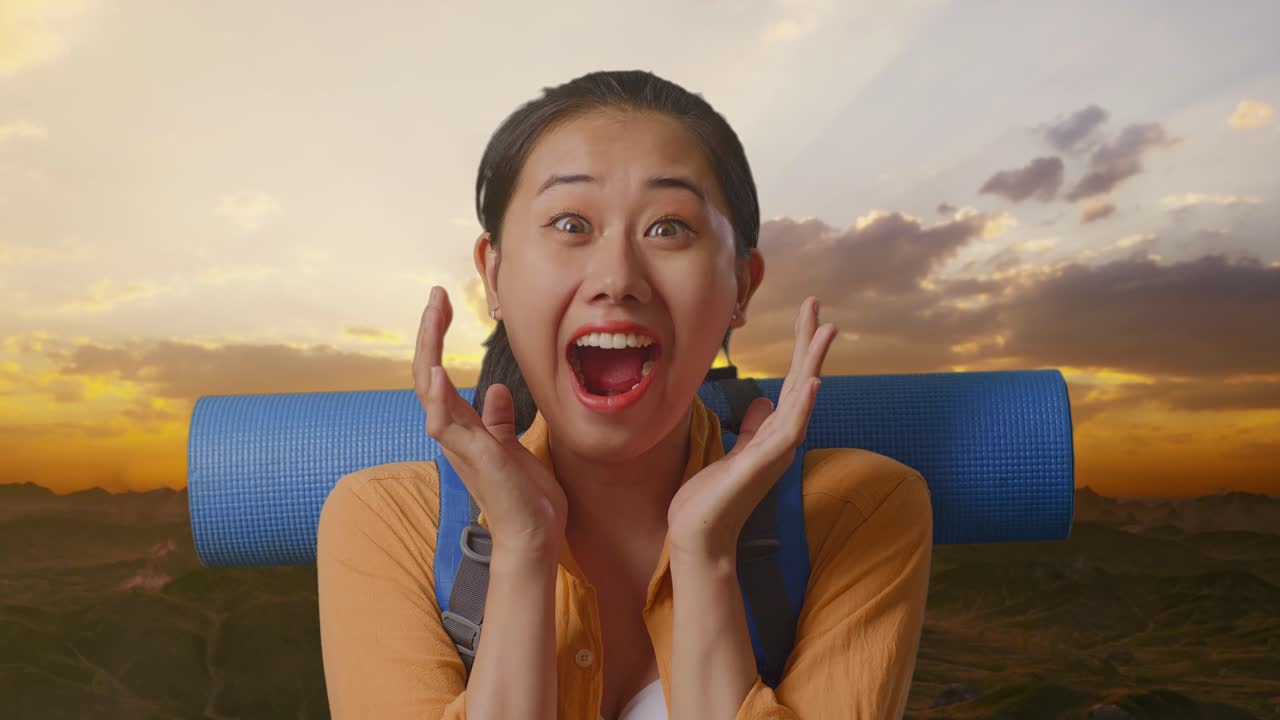 Close Up Of Asian Female Hiker With Mountaineering Backpack Saying Wow While Standing On The Top Of Mountain During Sunset Time