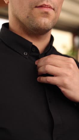 man adjusting shirt with gold watch