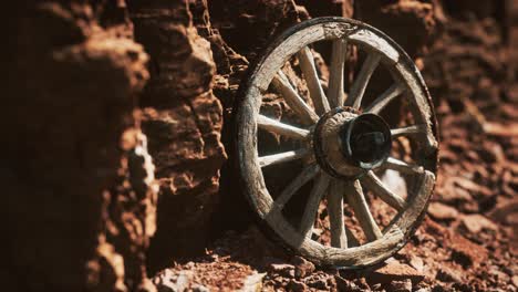 old wooden cart wheel on stone rocks