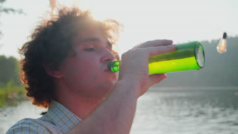 man drinking beer and speaking with friends at lake party