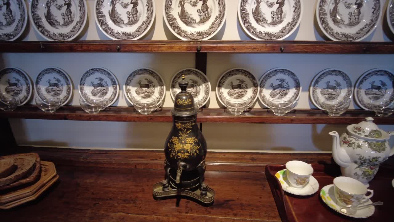 Row of old china plates on cabinet panning shot 4K