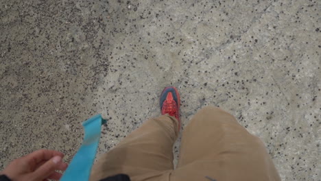 Male-Legs-and-Feets,-Walking-on-Dry-Barren-Desert-Ground,-Top-Down-POV-Full-Frame-Slow-Motion