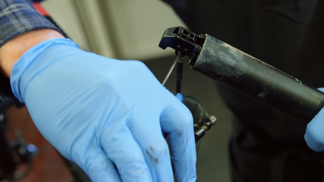 hombre reparando una bicicleta en el taller 4k
