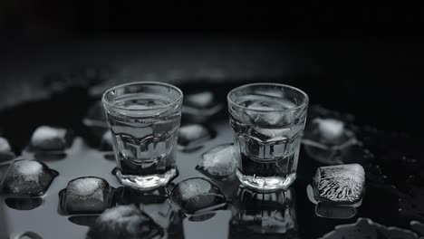 two shot glasses of vodka on ice