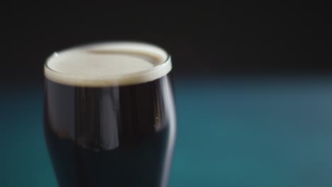 cerca de una pinta de cerveza negra irlandesa en vidrio para celebrar el día 13 de san patricio